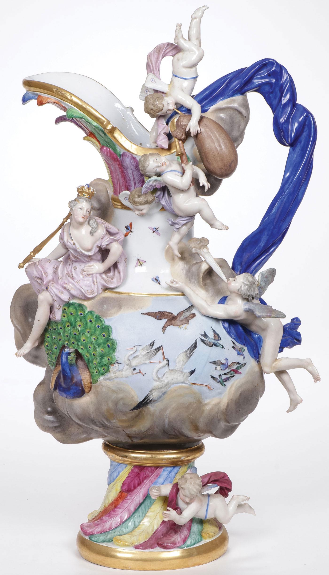 MEISSEN PORCELAIN 'ELEMENTS' EWER EMBLEMATIC: MEISSEN PORCELAIN 'ELEMENTS' EWER EMBLEMATIC OF AIR, 19th C. The billowing drape handle surmounted by two winged putti playing a bagpipe, the spout molded with bands of brightly colored feathers above