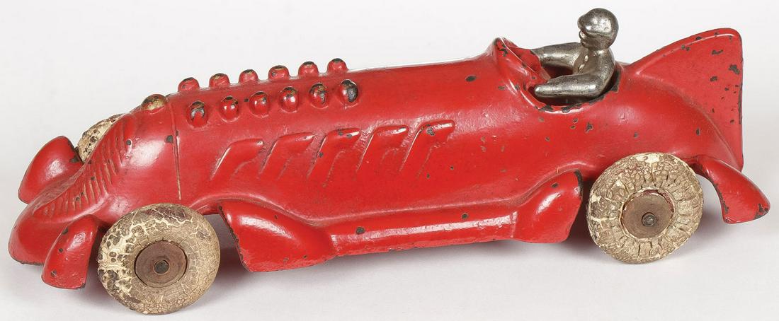 HUBLEY CAST IRON TOY RACE CAR C. 1930: HUBLEY CAST IRON TOY RACE CAR C. 1930. Original red paint, with tail fin, exhaust stacks, driver & white rubber tires and wooden hubs, one tire loose. Length 8.5 inches. SHIPPING NOTICE: Jackson's is