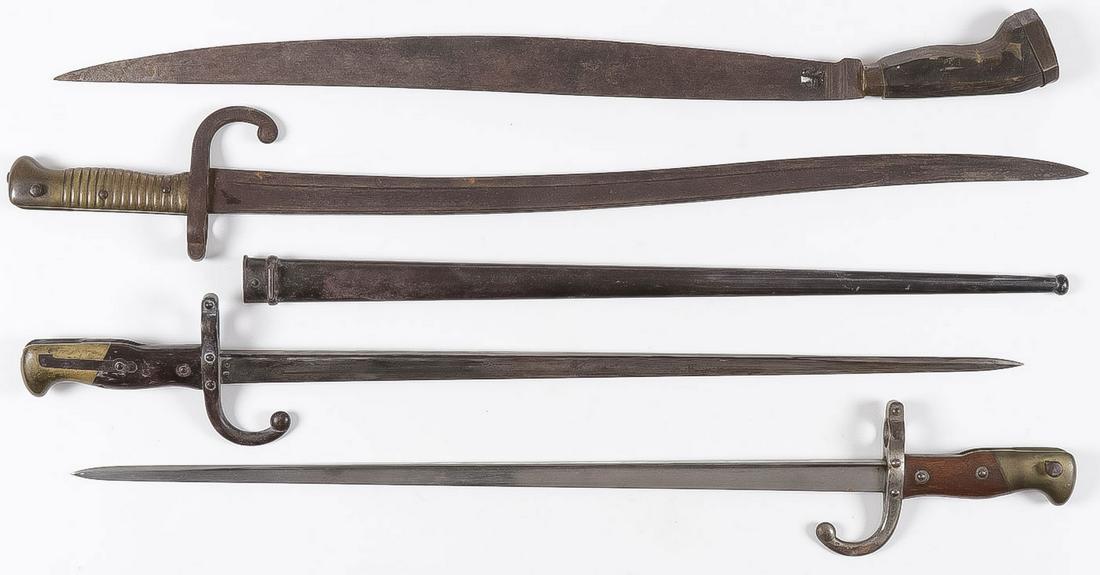 THREE VINTAGE BAYONETS AND MACHETE: THREE VINTAGE BAYONETS AND MACHETE. Comprising two French bayonets with flat spines, one with scabbard, one dated 1877, the other 1889. And a brass handled Yatagan example, dated 1872. Together with