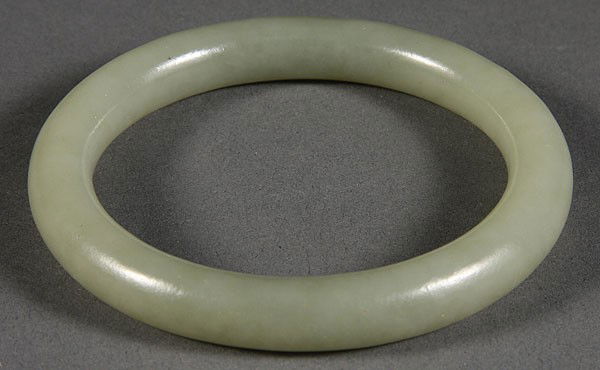 A VERY FINE CHINESE CARVED WHITE JADE BANGLE, 19TH/: A VERY FINE CHINESE CARVED WHITE JADE BANGLE, 19TH/20TH CENTURY. Of circular ring form carved in a fine semi-translucent pale celadon colored jade. Outside diameter 3.25 inches, inside diameter 2.375
