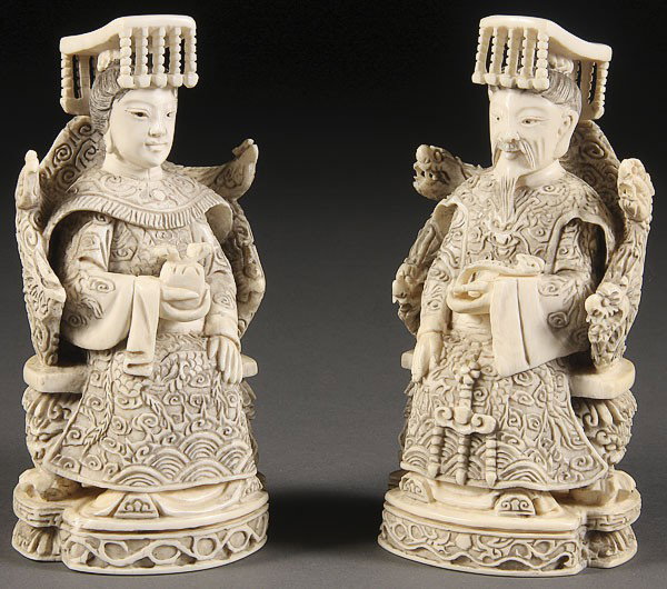 CHINESE CARVED IVORY EMPEROR AND EMPRESS: A PAIR OF CHINESE CARVED IVORY EMPEROR AND EMPRESS, 20TH CENTURY, well carved in seated form with ornate garments in fine relief, the Emperor holding a Ruyi scepter, the Empress holding a peach. Inscr