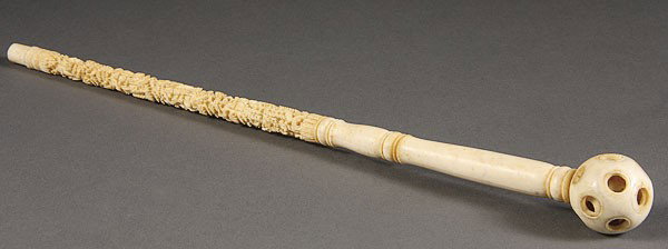 A CHINESE EXPORT CARVED IVORY PARASOL HANDLE: A CHINESE EXPORT CARVED IVORY PARASOL HANDLE, 19TH/20TH CENTURY. The elongated stem carved with a scenic relief of figures, pavilions and foliage terminating in a carved puzzle ball. Length 13 inches 