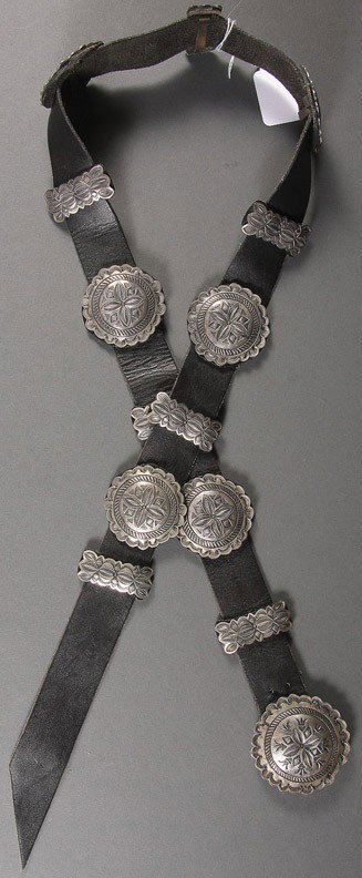 IDA MORGAN SOUTHWEST SILVER MOUNTED LEATHER BELT: AN IDA MORGAN SOUTHWEST SILVER MOUNTED LEATHER BELT, 20TH CENTURY, mounted with 6 each alternating round and rectangular medallions joined with a matching rosette buckle signed “Ida. Sterling”, le