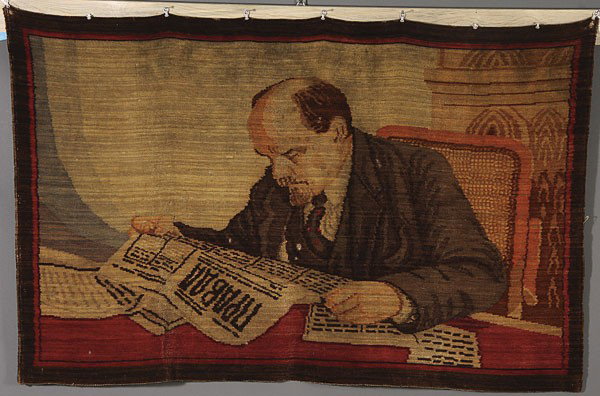 RUSSIAN SOVIET WOVEN LENIN WALL RUG: A RARE RUSSIAN SOVIET MACHINE WOVEN PROPAGANDA WALL HANGING of Lenin reading the newspaper Pravda, circa 1935, after the well-known photograph. 37 inches x 59 inches (94 x 150 cm). Excellent condition