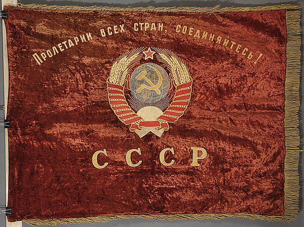 A RUSSIAN SOVIET EMBROIDERED BANNER LENINGRAD: A RUSSIAN SOVIET EMBROIDERED BANNER, CIRCA 1930-1940. Finely embroidered with crewel work. The verso acknowledging the Leningrad textile industry, and the borders fringed. 48 inches x 64 inches (122 x