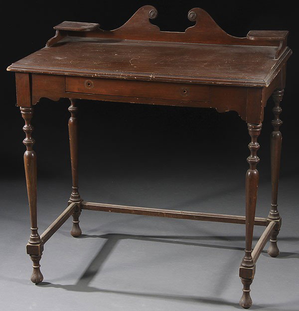 AN EARLY AMERICAN REVIVAL WRITING DESK, CIRCA 1925: AN EARLY AMERICAN REVIVAL WRITING DESK, CIRCA 1925. With a single drawer and candle stands flanking a broken pediment arch raised on turned spindle legs. Height 34 inches, width 32 inches, depth 20 in