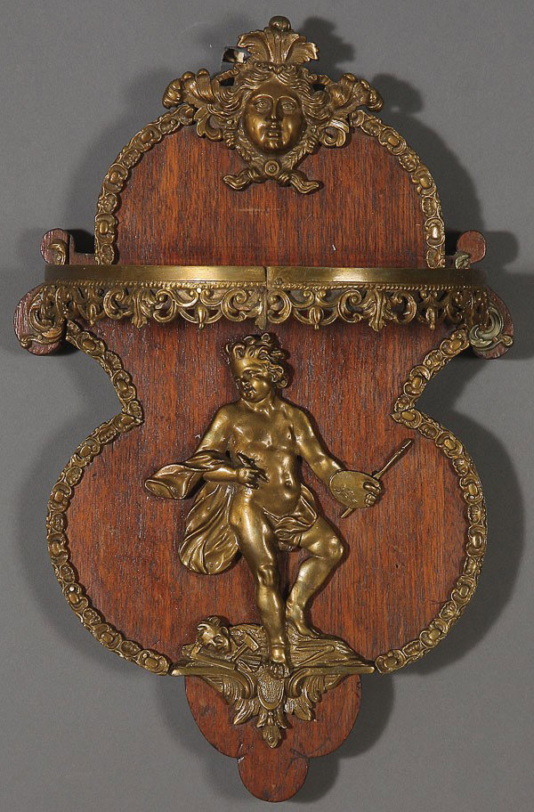 ITALIANATE ORMOLU MOUNTED WALNUT BRACKET SHELF: A GOOD ITALIANATE ORMOLU MOUNTED WALNUT BRACKET SHELF, 19TH CENTURY. Mounted with an embossed ormolu putto modeled as an artist, below a reticulate scrolled shelf surmounted by a facial mask of a youn
