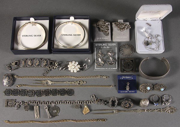 A GROUPING OF STERLING SILVER JEWELRY: A GROUPING OF STERLING SILVER JEWELRY including bracelets, chains, charms, tic tack cuff link sets, together with thimbles and pickle forks.