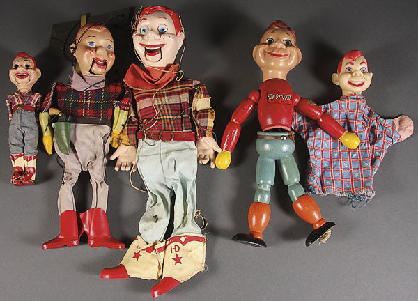 A GROUP OF FIVE HOWDY DOODY DOLLS AND MARIONETTES,: A GROUP OF FIVE HOWDY DOODY DOLLS AND MARIONETTES, MID 20TH CENTURY, comprising a wood and composition jointed doll, a large plastic Marionette, a composition Marionette, a hand puppet and a small pla