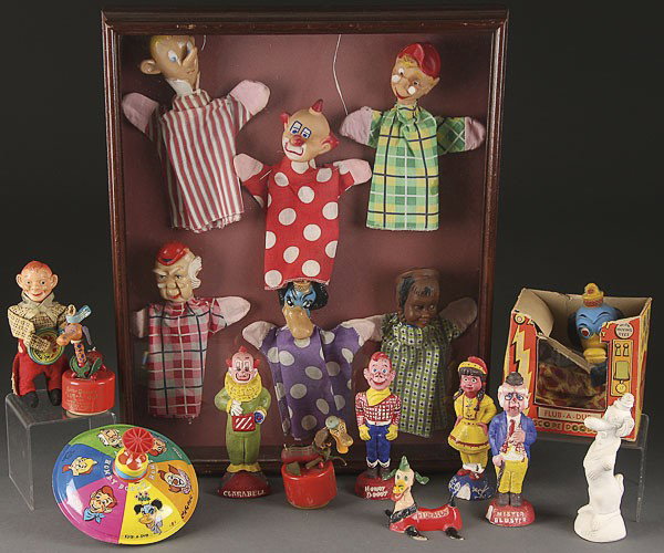 AN 18 PIECE HOWDY DOODY TOY AND NOVELTY GROUP: AN 18 PIECE HOWDY DOODY TOY AND NOVELTY GROUP, MID 20TH CENTURY, comprising a shadow box framed set of six character hand puppets, a Howdy Doody banjo playing wind up, a tin litho top, five cast chalk