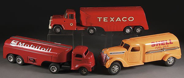 TOY GAS DELIVERY TRUCKS BUDDY L SMITH MILLER: A GROUP OF THREE TOY GASOLINE DELIVERY TRUCKS, MID 20TH CENTURY, comprising a Buddy L Texaco, a Smith Miller mobile oil (restored), and a Buddy L Shell (restored), the largest 23 inches.