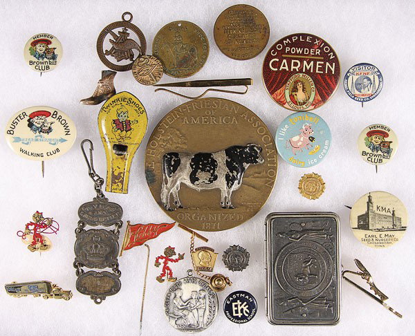 A BUSTER BROWN OTHER ADVERTISING VINTAGE PREMIUMS: BUSTER BROWN AND OTHER ADVERTISING VINTAGE PREMIUMS, EARLY 20TH CENTURY including Carmen pocket mirror, Buster Brown pin back, International tailoring, match safe, a Holstein Association bronze medal,
