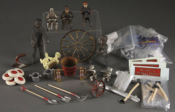 VINTAGE TOY PARTS BUDDY L HUBLEY: A GROUP OF VINTAGE TOY PARTS INCLUDING CAST IRON DRIVERS, rubber tires, Buddy L decals, a Hubley hook and ladder box, fire engine related items, and other pieces.