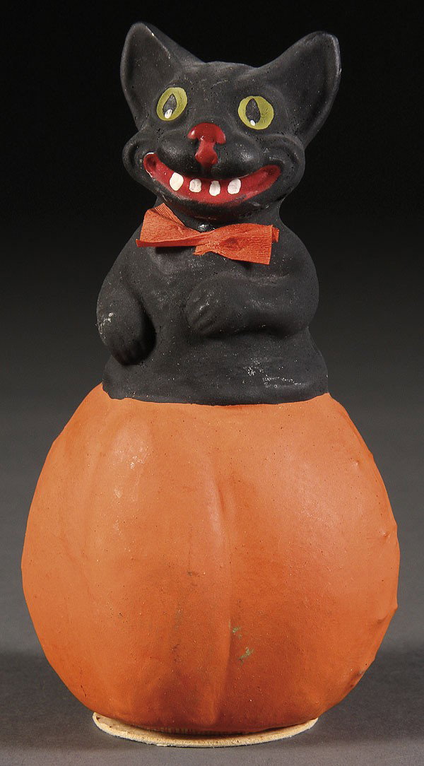 GERMAN PAPER MACHE BLACK CAT ON PUMPKIN HALLOWEEN: A VERY FINE GERMAN PAPER MACHE BLACK CAT ON PUMPKIN CANDY CONTAINER, EARLY 20TH CENTURY, marked Germany, near mint condition, height 5.5 inches.