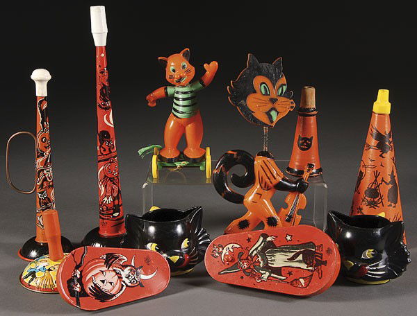 A 12 PIECE VINTAGE HALLOWEEN TOY AND NOVELTY GROUP: A 12 PIECE VINTAGE HALLOWEEN TOY AND NOVELTY GROUP. Comprising black cat plastic mugs, metal noise makers, a plastic cat nodder, cat on wheels, and an early die cut paper candy basket. The largest 11