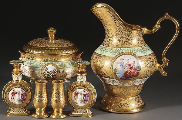 A SIX PIECE GROUP OF 22K GOLD PORCELAIN: A SIX PIECE GROUP OF 22K GOLD PORCELAIN, MID 20TH CENTURY. With romantic scenic transfer medallions, comprising a 10.5 inch pitcher, covered box and two dresser bottles, together with a pair of etched