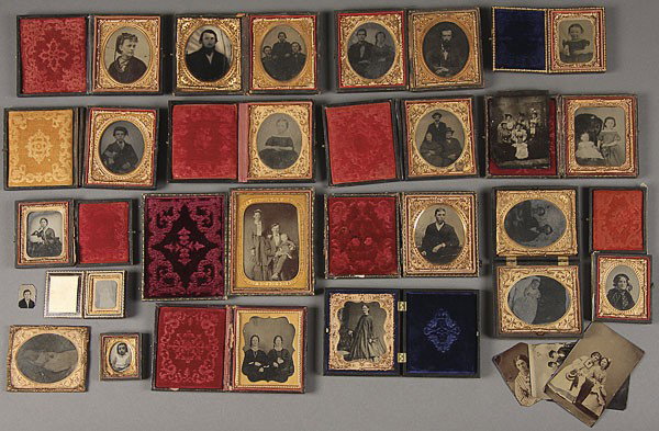 A GROUP OF 25 AMBROTYPE AND TINTYPE IMAGES: A GROUP OF 25 AMBROTYPE AND TINTYPE IMAGES, MID 19TH CENTURY. Mostly cased images comprising a very fine 1/4 plate tintype of a husband, wife and infant, well dressed and the infant with a red tinted