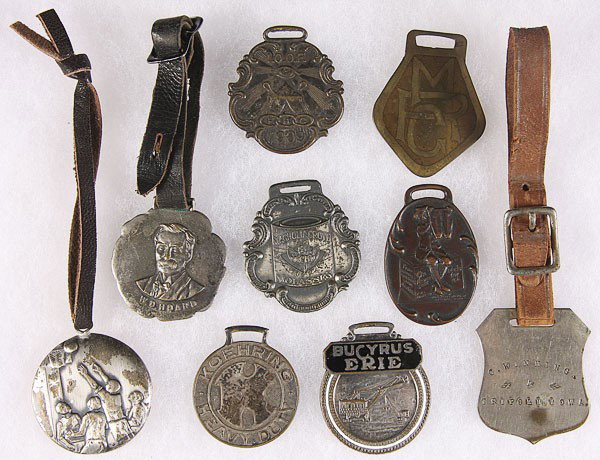 NINE VINTAGE AND ADVERTISING WATCH FOBS: NINE VINTAGE AND ADVERTISING WATCH FOBS, EARLY TO MID 20TH CENTURY. Including Bucyrus Eyre Advertising, Magnolia Molasses Advertising, and Odd Fellows and others.