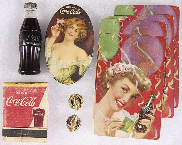 A RARE COCA-COLA CELLULOID POCKET MIRROR: A RARE COCA-COLA CELLULOID POCKET MIRROR TOGETHER WITH A MINIATURE COKE BOTTLE, four playing cards, a match book, and two gold service awards for 10 and 15 years.