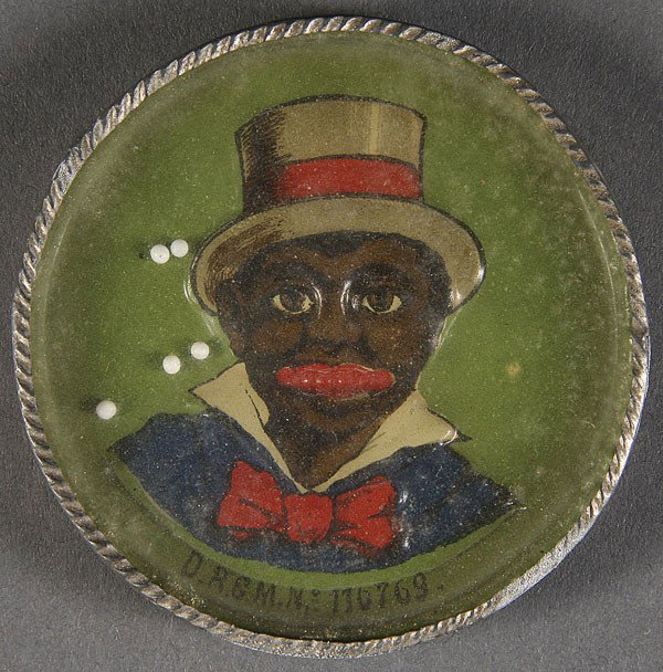 BLACK MEMORABILIA NOVELTY TOY, CIRCA 1900: A GERMAN NOVELTY TOY OF A BLACK MAN, CIRCA 1900. With embossed face designed to catch loose white balls (teeth). Diameter 2.5 inches.
