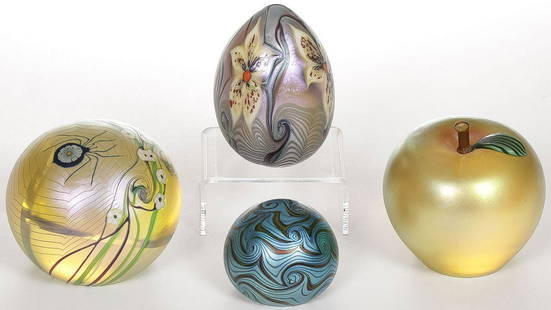 FOUR ORIENT & FLUME IRIDIZED GLASS PAPERWEIGHTS: FOUR ORIENT & FLUME IRIDIZED GLASS PAPERWEIGHTS. Each signed on underside, including an iridized gold apple with applied leaf and stem, height 3 inches, gold iridescent spider web and flower paperweig