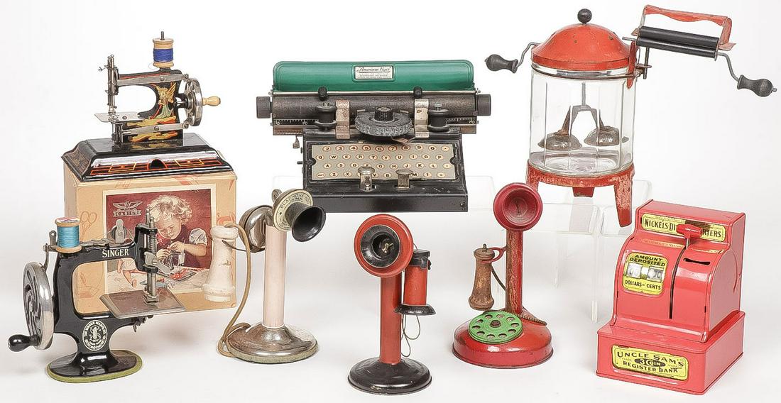 VINTAGE CHILDREN'S TOYS: VINTAGE CHILDREN'S TOYS. Comprising a tin and glass Wolverine washer ringer, an American Flyer typewriter, a Casige sewing machine in original box, a Singer child's sewing machine, three candlestick t