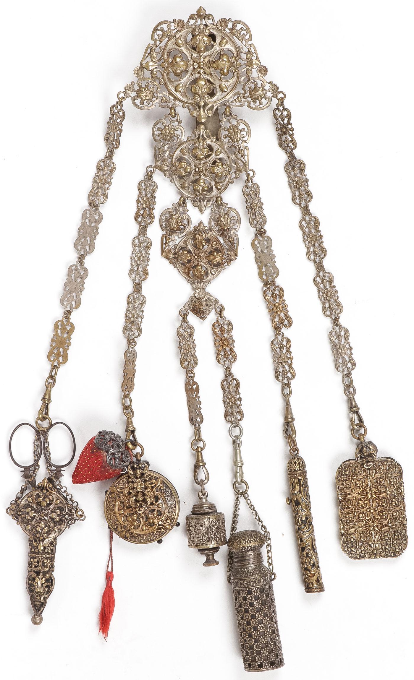 CHARMING VINTAGE CHATELAINE: CHARMING VINTAGE CHATELAINE. The silver metal frame with six drops terminating in scissors, pin holder, measuring tape, perfume bottle, pencil, and notebook. Apparently unmarked. Length 15 inches. NO 