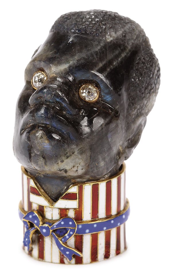 CARTIER STYLE CARVED & GEM SET AMERICAN BLACK HEAD: AN INTERESTING GEMSET AND ENAMEL CARVED LABRADORITE HEAD OF A BLACK MAN, IN THE MANNER OF CARTIER, CIRCA 1900. The head carved in full round, set with diamond eyes banded in gold and held in a gold an