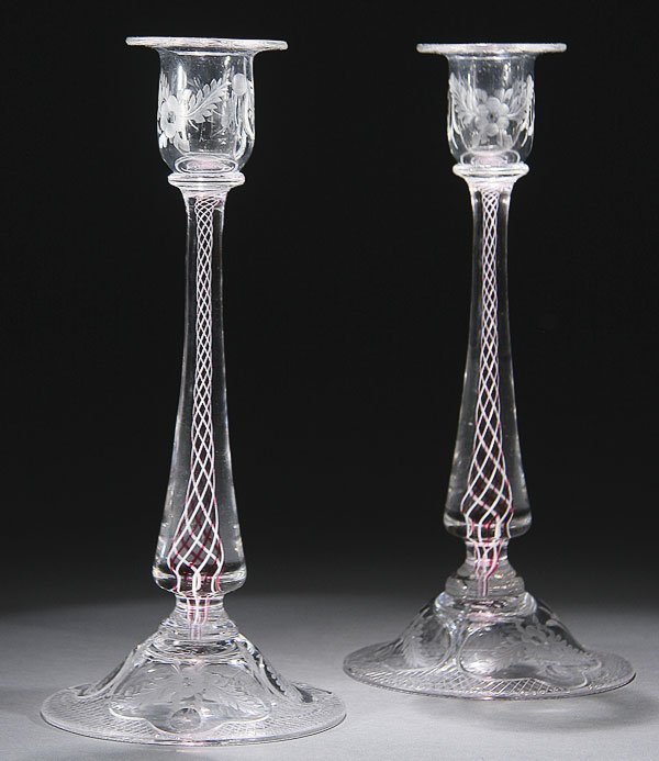 PAIRPOINT VENETI CRYSTAL & LATTICINO CANDLESTICKS: A VERY FINE PAIR OF AMERICAN PAIRPOINT "VENETI" WHEEL CUT CRYSTAL AND LATTICINO CANDLESTICKS, FIRST HALF 20TH CENTURY. Of baluster form with red and white twisted Latticino core stems on a floral and 