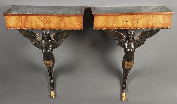 FRENCH EMPIRE CARVED EBONIZED CONSOLE TABLES: A PAIR OF FRENCH EMPIRE MARBLE, SATINWOOD AND CARVED EBONIZED CONSOLE TABLES, CIRCA 1800. Each with figural carved caryatid winged figural supports in ebonized wood with gilt highlights below a satinw