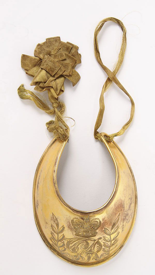 GEORGE III BRASS GORGET: AN ENGLISH OFFICERS COPPER-GILT GORGET, 1796-1815. With an engraved GR cipher below a Hanoverian crown and within a laurel wreath. Length 4.5 inches (11.5 cm).