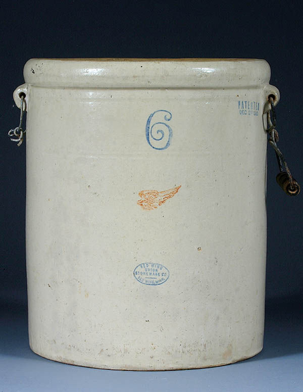 A REDWING 6 GALLON CROCK with small wing and blue: A REDWING 6 GALLON CROCK with small wing and blue oval marked "Union Stoneware Co." Missing one handle, chip on base. Height 15". Estimate $40-$80