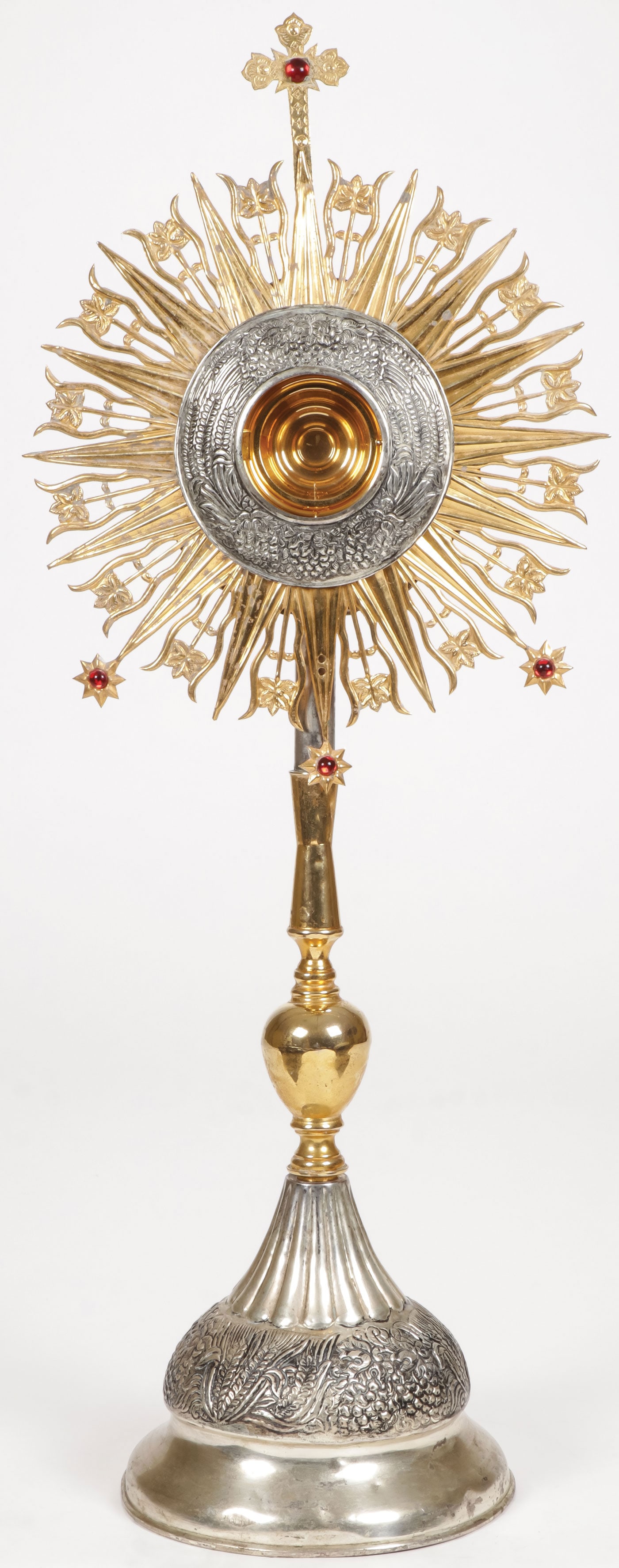 LARGE SPANISH COLONIAL MONSTRANCE: LARGE SPANISH COLONIAL MONSTRANCE Comprising a large and impressive monstrance, the conical base heavily reposed and ribbed and with gilt stem supporting a gilt sunburst frame centered with a silvered