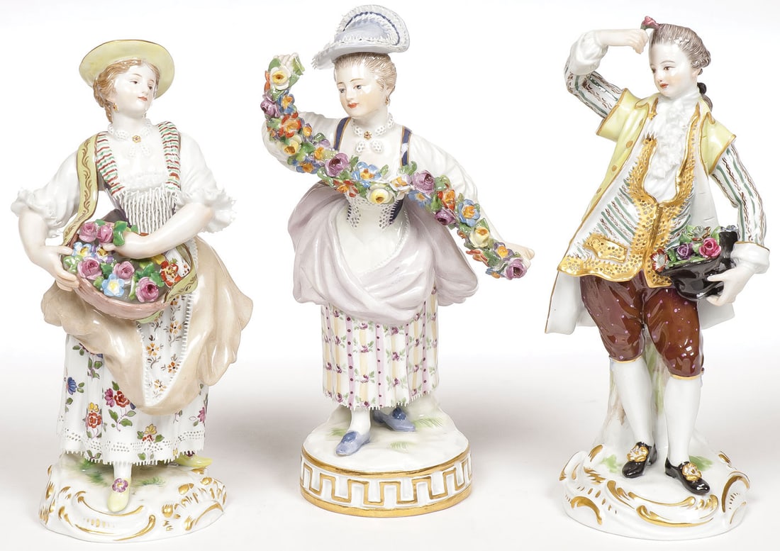 THREE MEISSEN PORCELAIN FIGURINES, 19TH C: THREE MEISSEN PORCELAIN FIGURINES, 19TH C Comprising two flower maidens and a man with a hat full of flowers. Underside of each with blue underglaze cross swords and impressed and incised numbers. Eac
