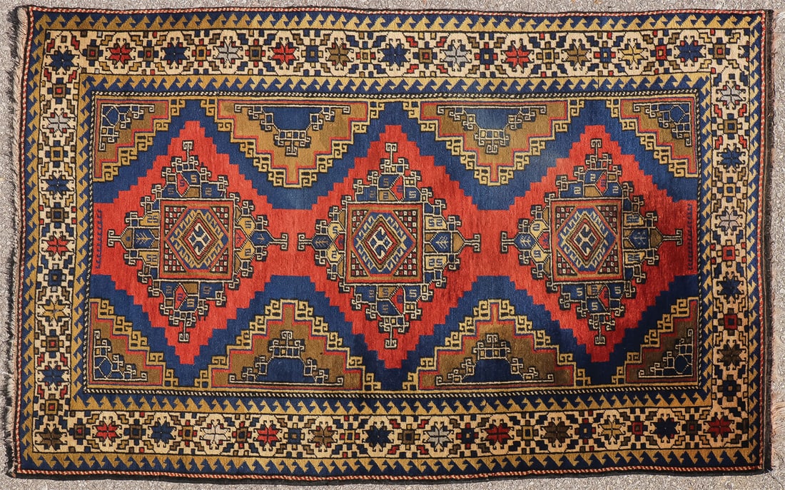 INTERESTING ORIENTAL RUG: INTERESTING ORIENTAL RUG With serrated red triple medallion on tan and blue ground, having an ivory border with repeating floral pattern, 43.5 inches x 66 inches. SHIPPING NOTICE: Jackson's is your s