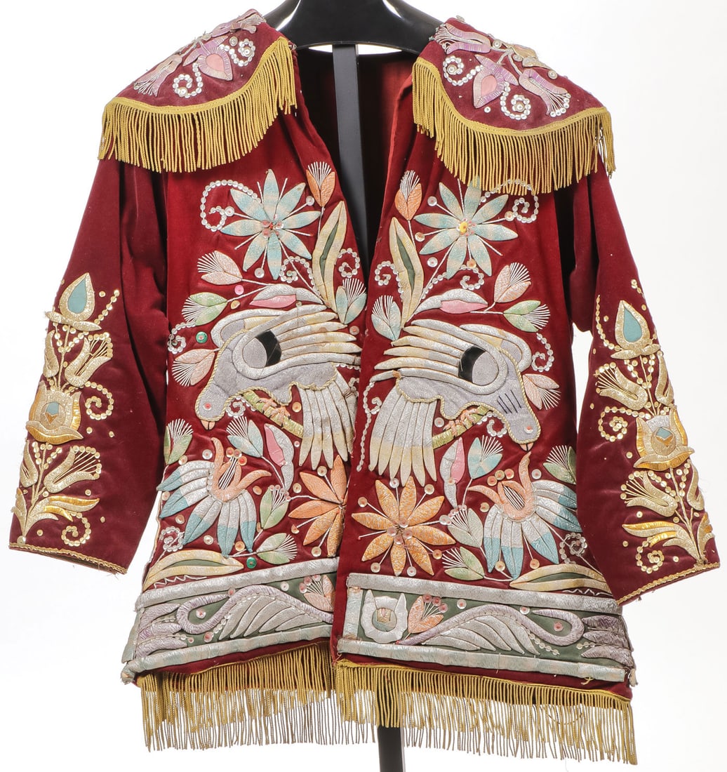 EMBROIDERED PERUVIAN PARADE JACKET: EMBROIDERED PERUVIAN PARADE JACKET The maroon velvet body profusely beaded in multicolored metal thread depicting parrots, butterfly on cape, and Saint George on verso, and with fringe hem, height 30 