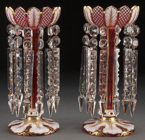 BOHEMIAN CUT OVERLAY CRYSTAL MANTLE LUSTRES: A VERY FINE PAIR OF BOHEMIAN CUT OVERLAY CRYSTAL AND GILT DECORATED MANTLE LUSTRES, CIRCA 1900. Of elongated, stylized floral form in cranberry colored glass overlaid in white opaque and finely cut wi