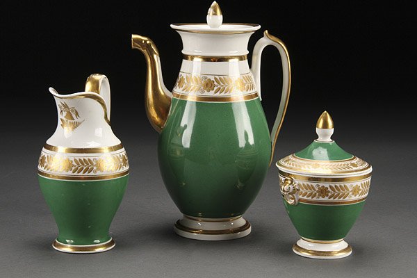 A FINE FRENCH OLD PORCELAIN THREE PIECE COFFEE SET: A FINE FRENCH OLD PORCELAIN THREE PIECE COFFEE SET, EARLY 19TH CENTURY. Comprising a pot with animal head spout, covered sugar and cream jug each with gilt laurel bands above an emerald green ground. 