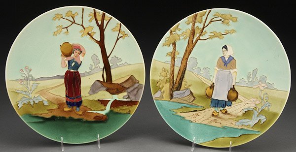 FRENCH FAIENCE WALL CHARGERS: A PAIR OF FRENCH LONGCHAMP FAIENCE GLAZED SCENIC WALL CHARGERS, LATE 19TH CENTURY. Each depicting a woman with water or wine jugs in country setting with raised outlining, impressed "Longchamp Terre d