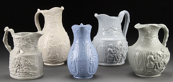 FIVE STAFFORDSHIRE SALT GLAZE PITCHERS: FIVE STAFFORDSHIRE SALT GLAZE PITCHERS, EARLY TO MID 19TH CENTURY. Comprising a mason's scene of revelers, a drinking scene marked "Willie" and two "International" by WM. Brownfield in white and blue.