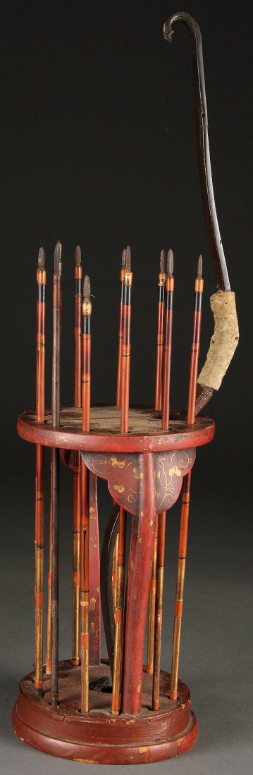 A RARE JAPANESE MODEL OF A SAMURAI BOW AND ARROWS: A RARE JAPANESE MODEL OF A SAMURAI BOW AND ARROWS IN LACQUERED STAND, MEIJI PERIOD, 19TH CENTURY. Comprising a carved wood recurve bow with leaf form terminals contained in a red lacquer and gilt scro