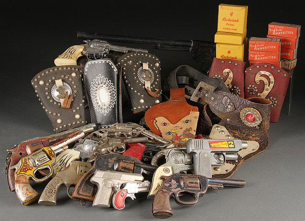 A VINTAGE WESTERN TOY CAP GUN GROUP: A VINTAGE WESTERN TOY CAP GUN GROUP, MID 20TH CENTURY. Cast iron, diecast and tin litho; over 30 guns and holsters, comprising a Kilgore "Trooper Safety" and "Zip" cast iron, Red Ranger and Kit Carso