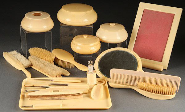 VINTAGE CELLULOID DRESSER ITEMS, 24 PIECES: A 24 PIECE COLLECTION OF VINTAGE CELLULOID DRESSER ITEMS, EARLY 20TH CENTURY. Including tray, picture frame, covered boxes, brushes, hand mirror and other pieces.