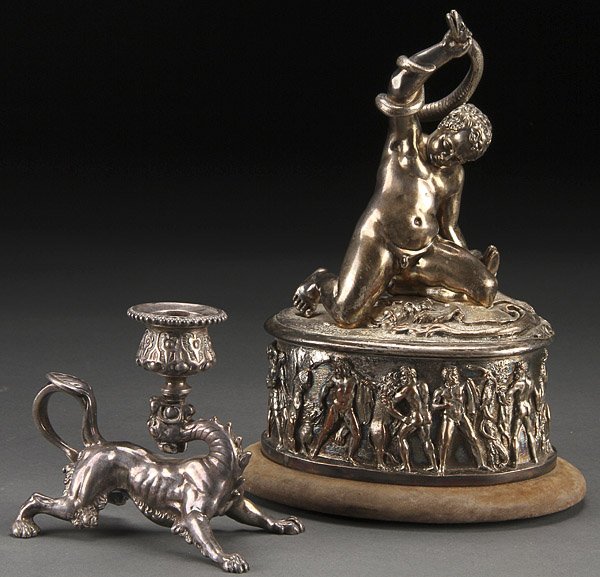 A FRENCH EMPIRE SILVERED COPPER HERCULES WITH SNAKE: A FRENCH EMPIRE SILVERED COPPER FIGURAL ORNAMENT, EARLY 19TH CENTURY. Depicting a young infant Hercules grappling a snake atop a pedestal with Greco-Roman warriors in relief and with Greek inscription
