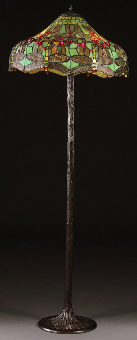 TIFFANY STYLE REPRODUCTION FLOOR LAMP: A TIFFANY REPRODUCTION DRAGON HEAD SHADE STAINED GLASS FLOOR LAMP, LATE 20TH CENTURY. Cast metal base with stamped metal column. Height 66 inches, diameter 24 inches.