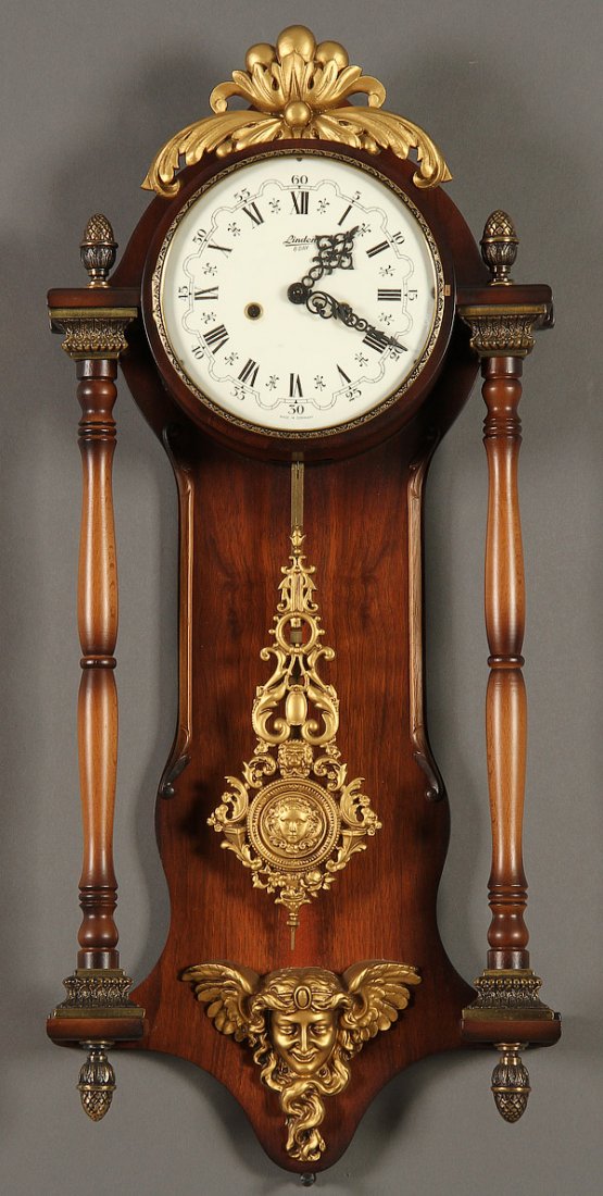 A GERMAN EIGHT DAY WALL CLOCK BY LINDEN: A GERMAN EIGHT DAY WALL CLOCK BY LINDEN, 20TH CENTURY. With mahogany turned columns and spelter figural/acanthus design. Length 28 inches (41.1 cm).