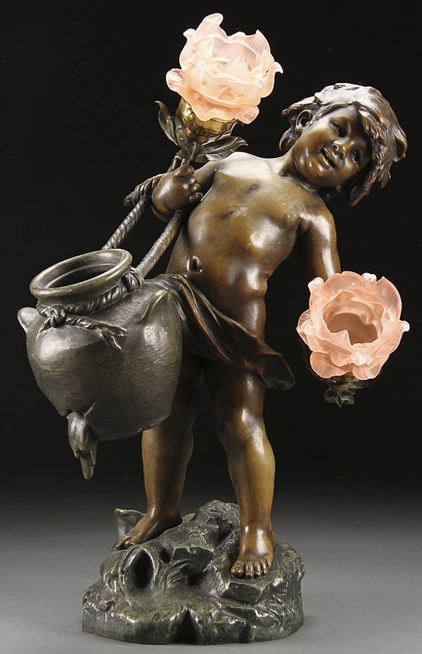 AFTER AUGUSTE MOREAU, A FIGURAL PARLOR LAMP: AFTER AUGUSTE MOREAU, A FIGURAL PARLOR LAMP OF AN INFANT WATER CARRIER, EARLY 20TH CENTURY. Cast metal with bronzed finish displaying two floriform lamps with petal form glass shades, signed on base "