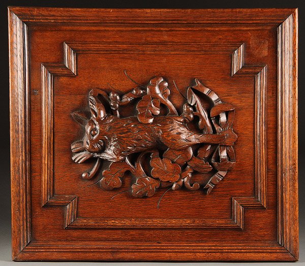 A SWISS CARVED BLACK FOREST OAK GAME PANEL: A SWISS CARVED BLACK FOREST OAK GAME PANEL, CIRCA 1900. Depicting a rabbit and oak leaves carved in deep relief within a molded framework, panel surround later mounted for hanging, 22.5 inches x 20.75