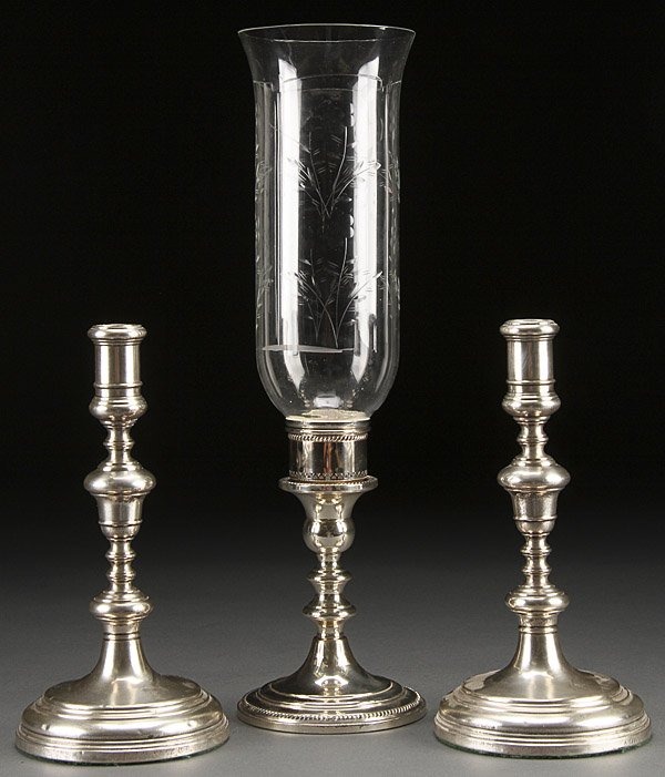 A THREE PIECE SILVER CANDLESTICK GROUP: A THREE PIECE SILVER CANDLESTICK GROUP, EARLY 20TH CENTURY. Comprising a pair of English George II style candlesticks by Charles and Richard Comyns, London, 1923; together with a sterling weighted can
