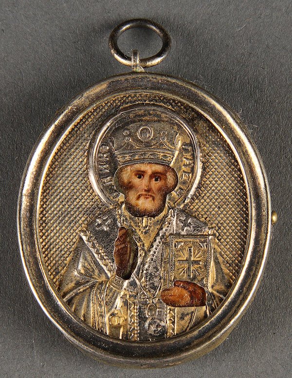 A RUSSIAN ICON OF ST. NICHOLAS WITH SILVER RIZA: A RUSSIAN ICON OF ST. NICHOLAS WITH SILVER RIZA, CIRCA 1900. Hallmarked Moscow, Cyrillic markers mark S.G., and 84 silver standard, with suspension loop, 1.75 inches x 1.5 inches (4.5 x 3.8 cm).